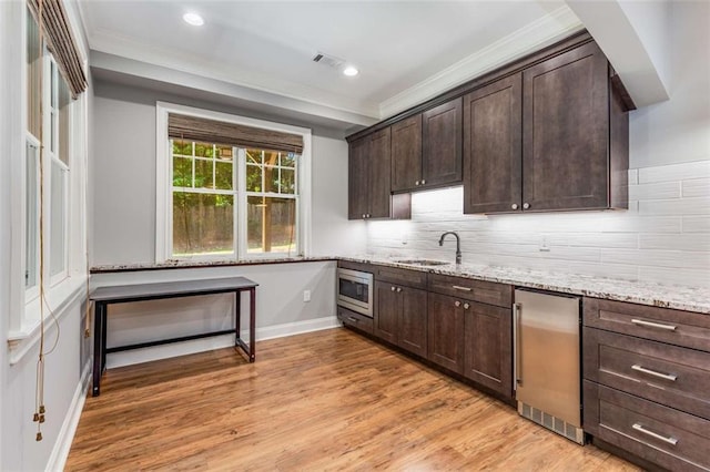 504 S Westminster Way NE, Atlanta, GA 30307 - kitchen featuring fridge, crown molding, dark brown cabinetry, light stone countertops, and light wood-type flooring