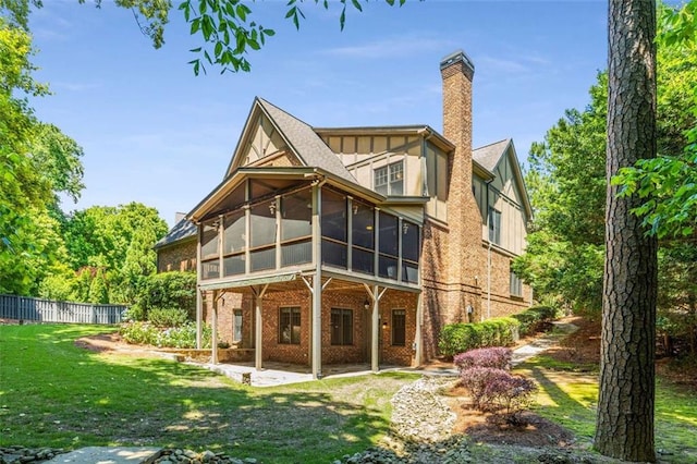 504 S Westminster Way NE, Atlanta, GA 30307 - rear view of property with a sunroom, brick siding, a patio, a chimney, and board and batten siding
