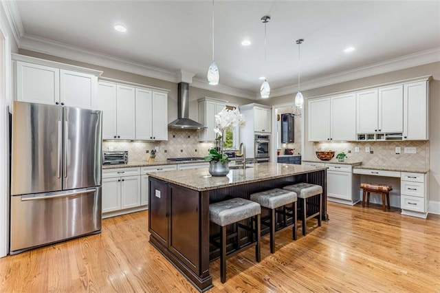 504 S Westminster Way NE, Atlanta, GA 30307 - kitchen with appliances with stainless steel finishes, wall chimney range hood, a kitchen bar, a sink, and backsplash