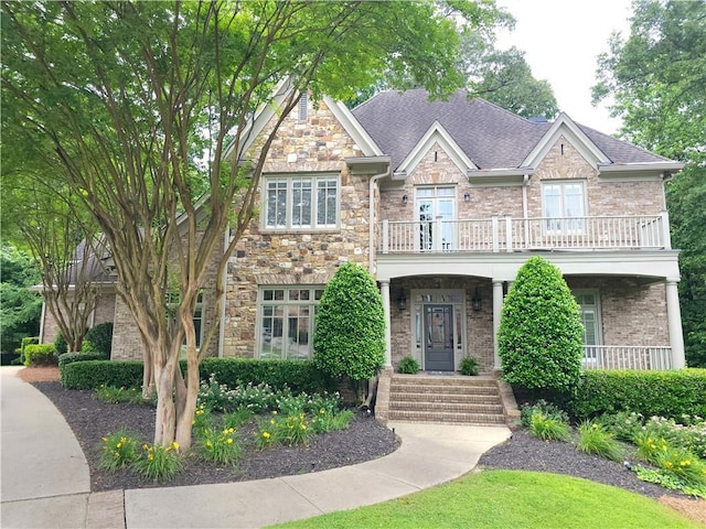 1632 Brookhaven Close NE, Brookhaven, GA 30319 - view of front facade featuring a balcony, brick siding, a shingled roof, and french doors