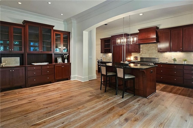 1632 Brookhaven Close NE, Brookhaven, GA 30319 - kitchen with custom exhaust hood, range, wood finished floors, dark countertops, and a kitchen breakfast bar