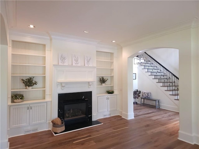 1632 Brookhaven Close NE, Brookhaven, GA 30319 - living area with ornamental molding, built in shelves, wood finished floors, a glass covered fireplace, and baseboards