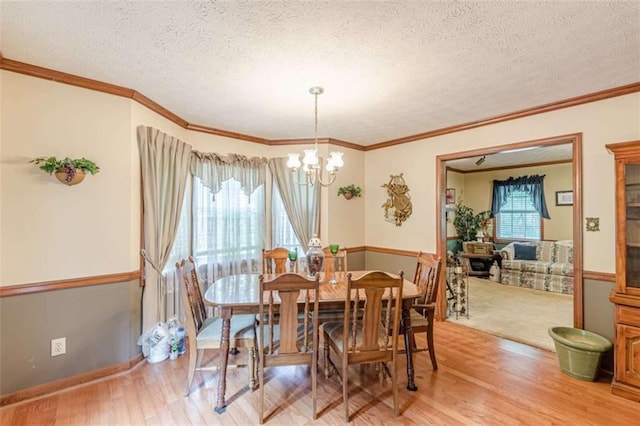 4411 Westerling Ct, Powder Springs, GA 30127 - dining area with light wood finished floors, a chandelier, a textured ceiling, and ornamental molding