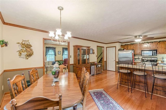 4411 Westerling Ct, Powder Springs, GA 30127 - dining area featuring light wood-type flooring, a chandelier, a textured ceiling, ceiling fan, and stairs