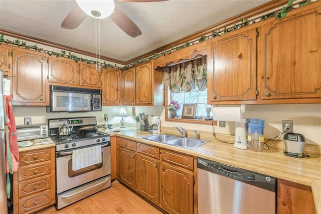 4411 Westerling Ct, Powder Springs, GA 30127 - kitchen with stainless steel appliances, light countertops, brown cabinetry, and a textured ceiling