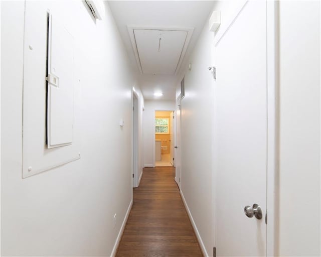 hallway with dark wood-type flooring, attic access, and baseboards