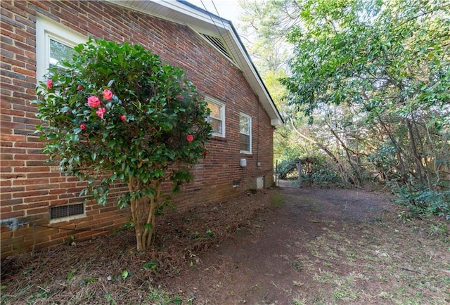 view of home's exterior featuring brick siding and crawl space