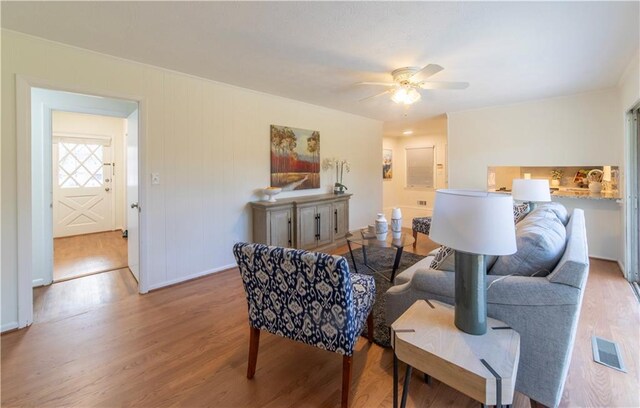 living area with ceiling fan, wood finished floors, and visible vents