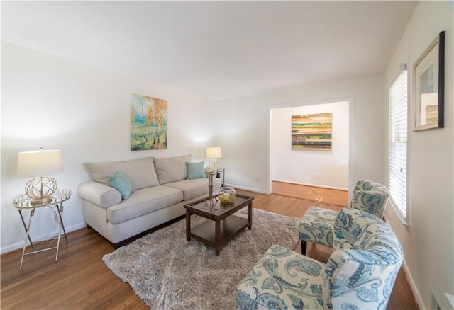 living room featuring visible vents, baseboards, and wood finished floors
