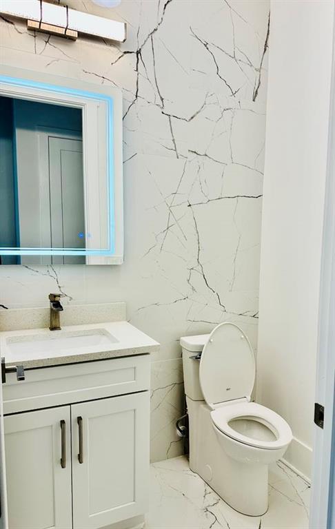 2964 Old Peachtree Rd, Dacula, GA 30019 - bathroom featuring toilet, tile walls, marble finish floor, and vanity