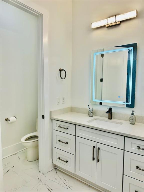 2964 Old Peachtree Rd, Dacula, GA 30019 - bathroom featuring vanity, marble finish floor, baseboards, and toilet