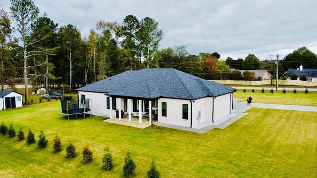 2964 Old Peachtree Rd, Dacula, GA 30019 - rear view of house featuring a trampoline, a lawn, a storage shed, a patio area, and an outdoor structure