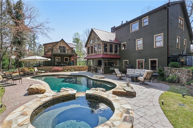 view of pool with an outdoor living space, an in ground hot tub, and a patio area