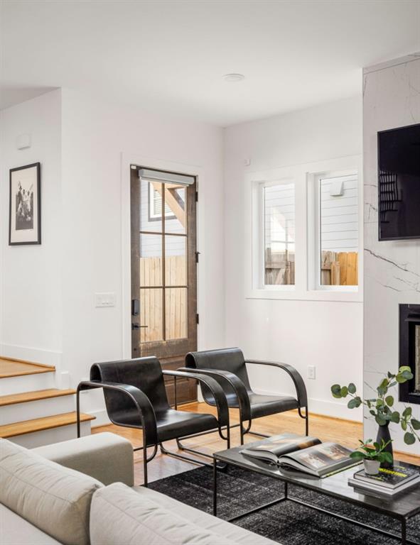 living room with a premium fireplace and wood finished floors