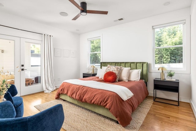 bedroom featuring multiple windows, french doors, and light wood-type flooring