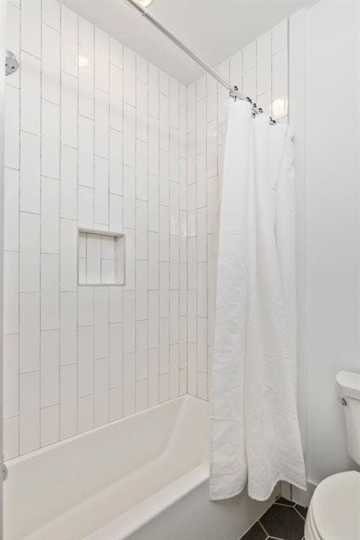 bathroom featuring tile patterned floors, shower / tub combo, and toilet