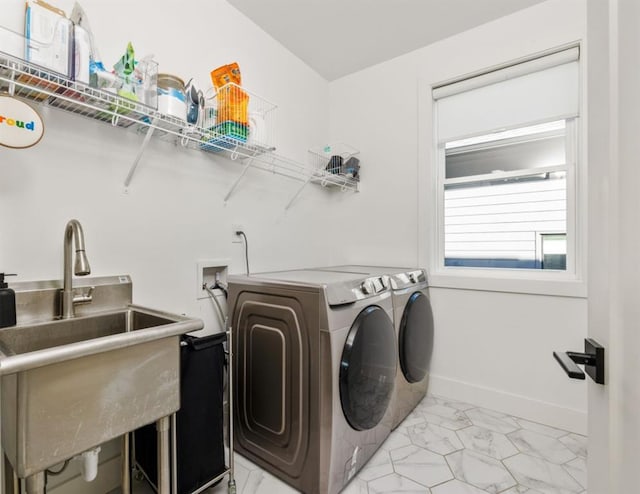 washroom featuring baseboards, washer and clothes dryer, laundry area, marble finish floor, and a sink