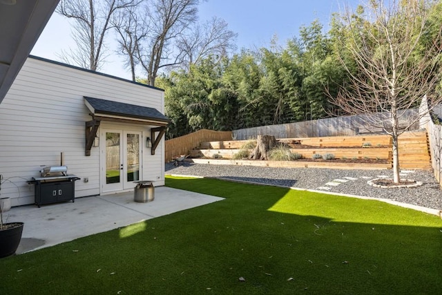 view of yard with a fenced backyard, french doors, and a patio