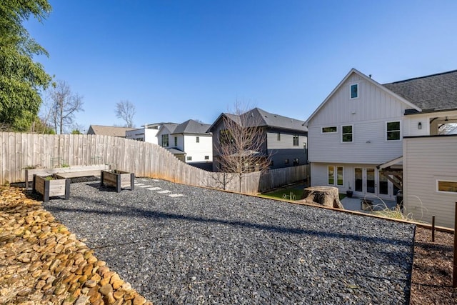 view of yard with a residential view, a fenced backyard, and a garden