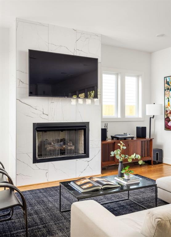 living area featuring wood finished floors and a high end fireplace