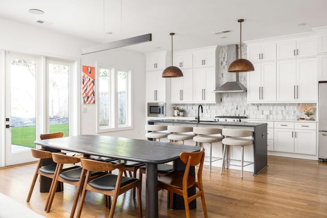 dining area featuring visible vents and light wood-type flooring