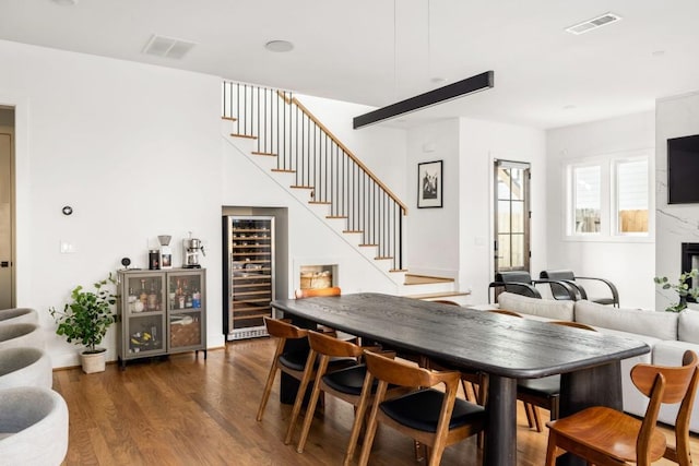 dining room with stairs, wine cooler, wood finished floors, and visible vents