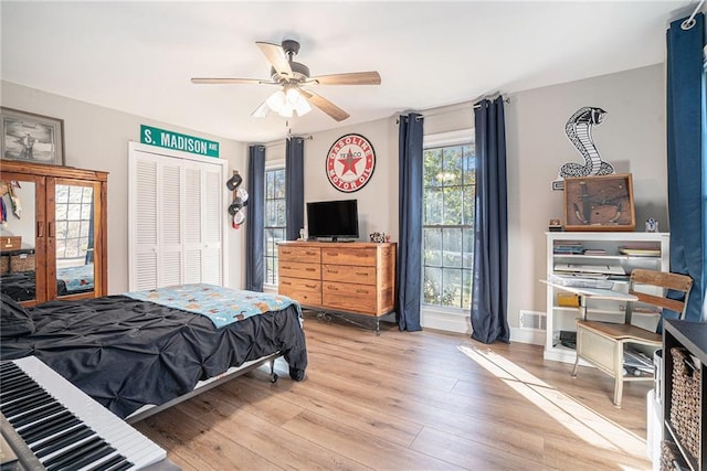 bedroom with light hardwood / wood-style floors, a closet, and ceiling fan