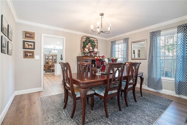 dining area featuring crown molding, hardwood / wood-style floors, and an inviting chandelier