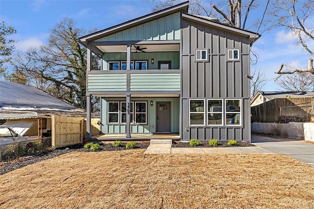 view of front of house with ceiling fan and a balcony