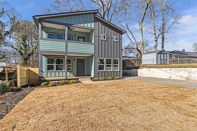 view of front of property featuring ceiling fan and a balcony