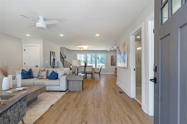 living room with ceiling fan and light wood-type flooring