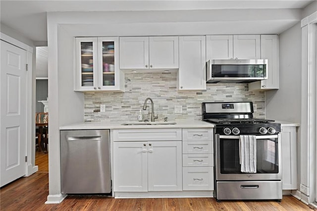 9470 Hillside Dr, Roswell, GA 30076 - kitchen with appliances with stainless steel finishes, white cabinets, light countertops, and wood finished floors