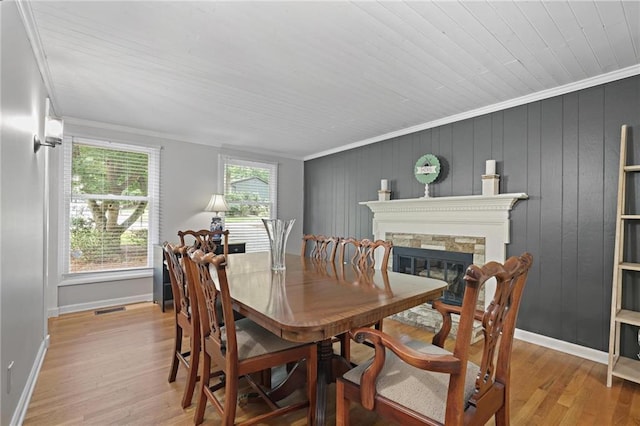 9470 Hillside Dr, Roswell, GA 30076 - dining space featuring crown molding, light wood-style floors, a stone fireplace, wooden ceiling, and wooden walls