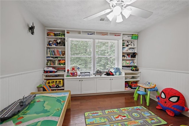 9470 Hillside Dr, Roswell, GA 30076 - game room featuring a textured ceiling, wood finished floors, a ceiling fan, and a wainscoted wall