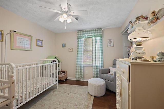 9470 Hillside Dr, Roswell, GA 30076 - bedroom featuring wood finished floors, a textured ceiling, a crib, and a ceiling fan