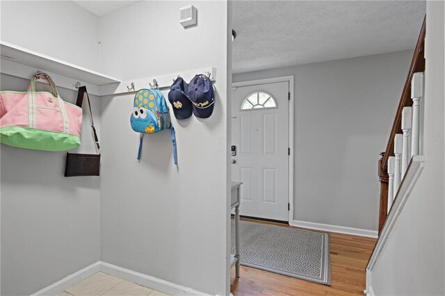 9470 Hillside Dr, Roswell, GA 30076 - foyer entrance with a textured ceiling, stairs, and wood finished floors