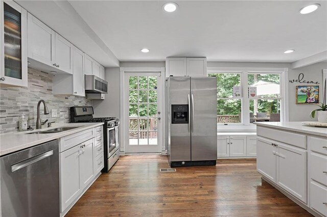 9470 Hillside Dr, Roswell, GA 30076 - kitchen with stainless steel appliances, white cabinetry, light countertops, decorative backsplash, and recessed lighting