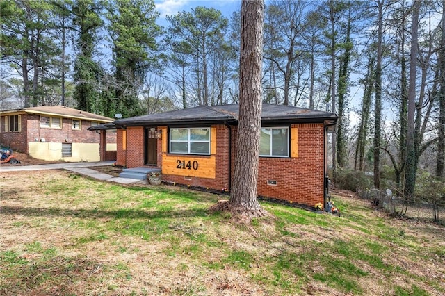 view of front of property featuring crawl space, a front yard, fence, and brick siding