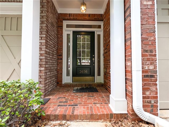 doorway to property featuring brick siding and a porch