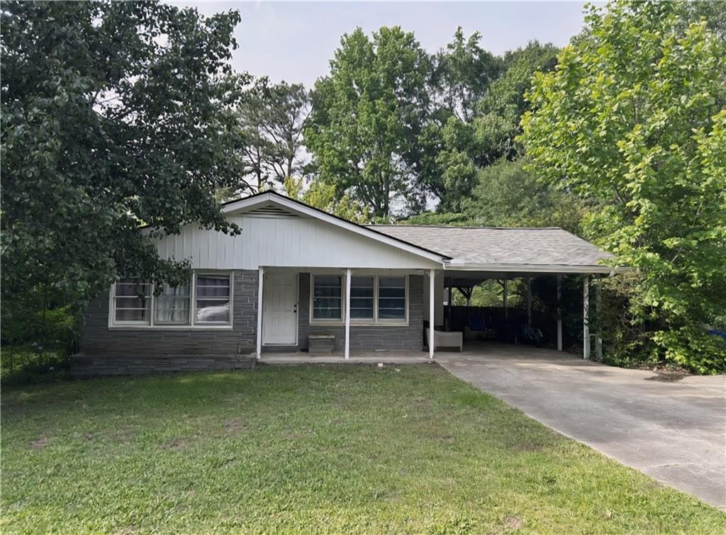 1176 Cardinal Rd NE, Conyers, GA 30012 - view of front facade featuring a front lawn, covered porch, concrete driveway, and a carport