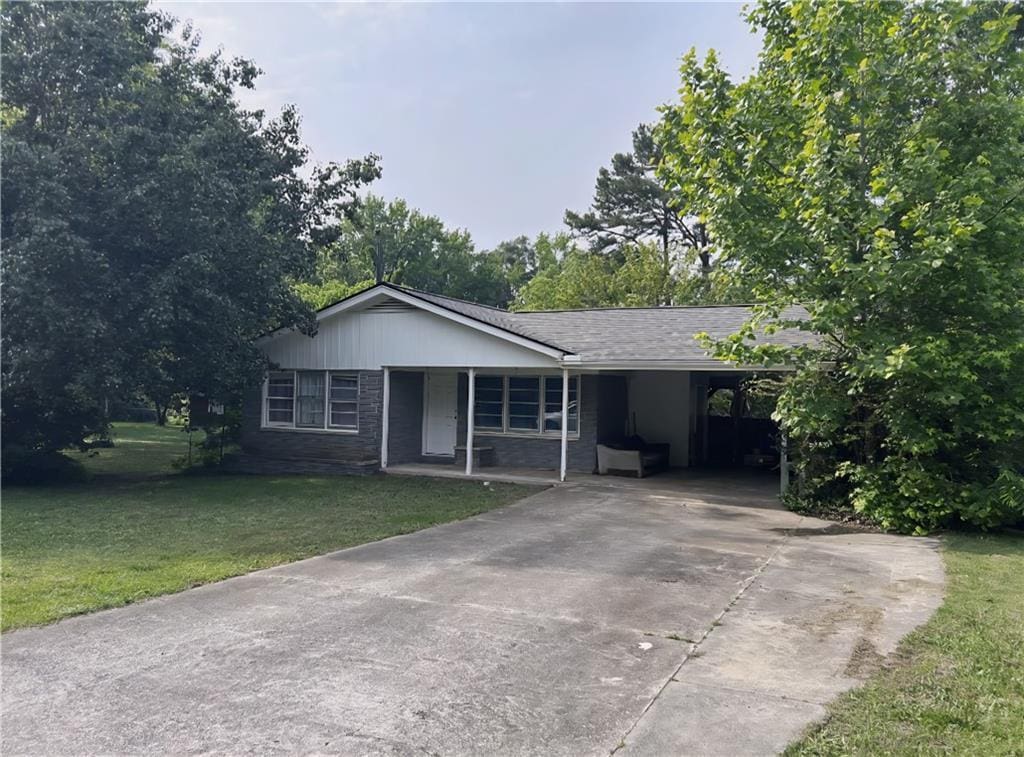 1176 Cardinal Rd NE, Conyers, GA 30012 - single story home with concrete driveway, a front yard, and a carport