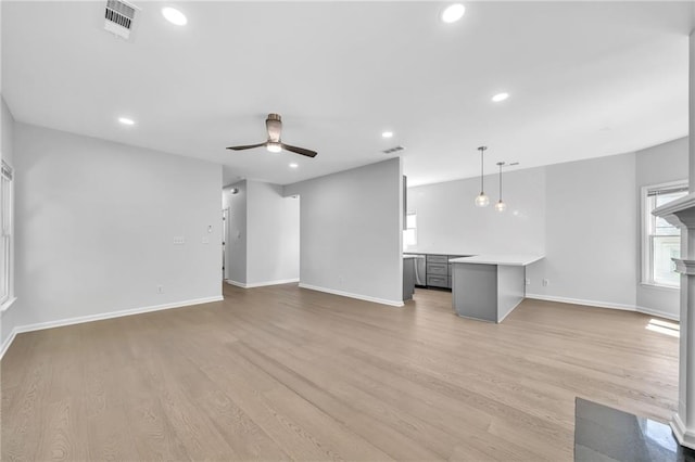 unfurnished living room featuring ceiling fan and light wood-type flooring