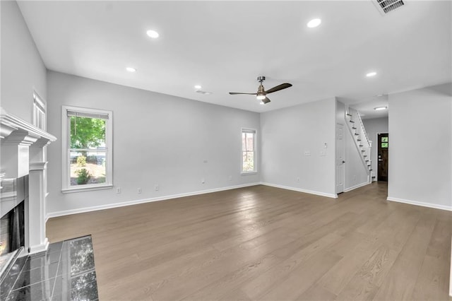 unfurnished living room featuring ceiling fan, plenty of natural light, and light hardwood / wood-style floors