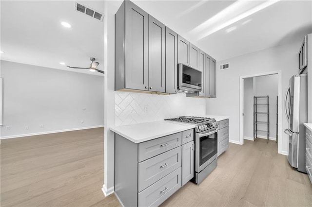 kitchen with stainless steel appliances, gray cabinets, and ceiling fan