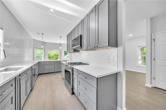 kitchen featuring backsplash, gray cabinets, sink, and stainless steel appliances