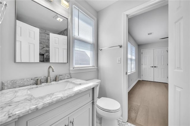 bathroom with vanity, hardwood / wood-style flooring, toilet, and a healthy amount of sunlight