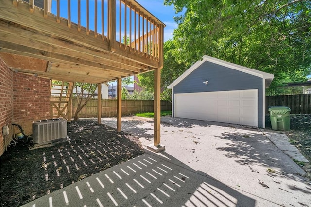 view of patio with a wooden deck, an outbuilding, central AC unit, and a garage