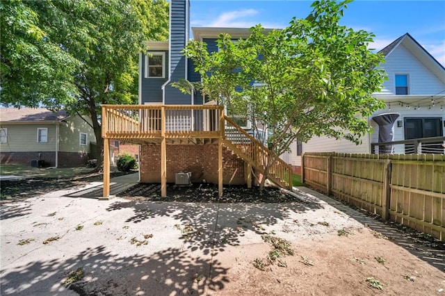 rear view of property featuring central AC unit and a wooden deck