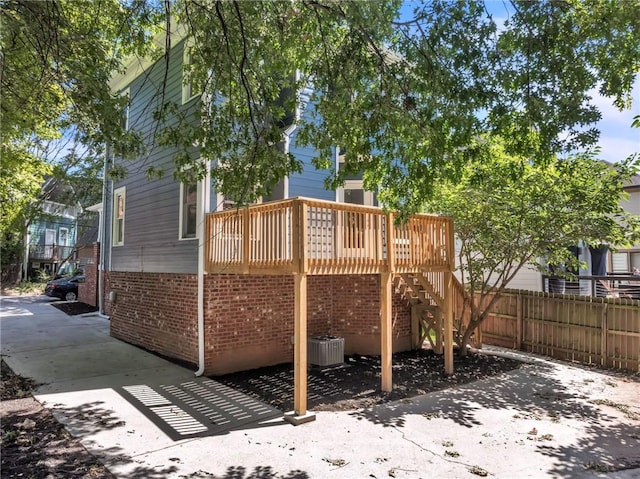 back of house with central AC unit and a deck