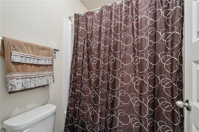 bathroom featuring toilet and a shower with curtain